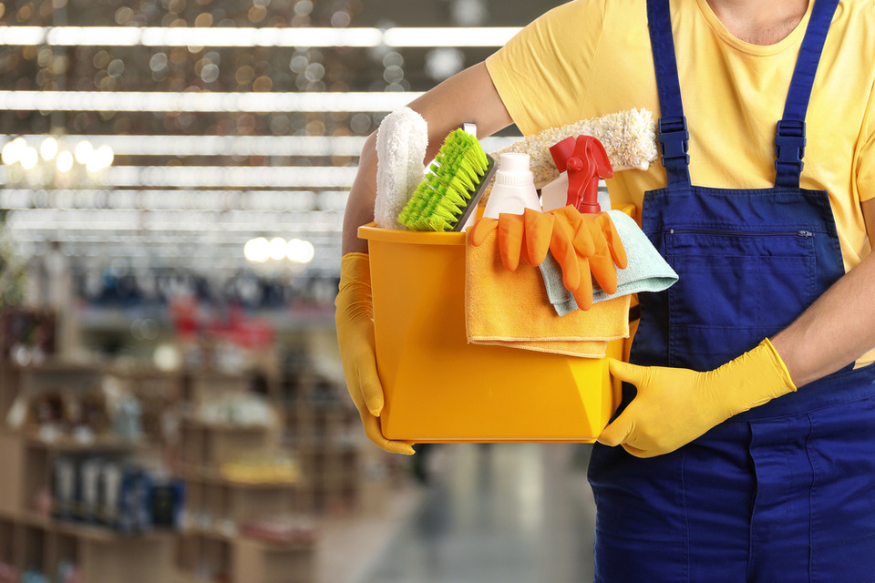 Person holding cleaning materials bucket